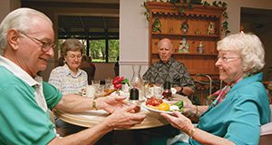 A photo of four older adults seated at the dinner table.