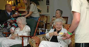 a photo of a group of people at a senior citizens center eating and drinking