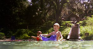 children swimming in a natural area