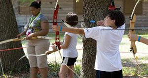 Three youth shooting bow and arrow