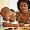 A woman helping her children with homework.