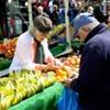 Un anciano y una anciana que compran fruta.