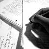 Black and white photo of a hand writing in a notebook.