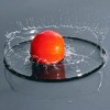 A tomato splashing water.