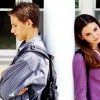 A teenage boy and girl facing away from each other.