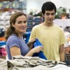 A mother clothes shopping with her teenage son.