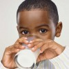 A young boy drinking milk.
