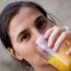 A woman drinking orange juice.