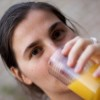 Una mujer bebiendo jugo de naranja.