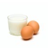 Two brown eggs and a glass of milk.