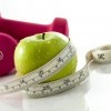 An apple wrapped in measuring tape.
