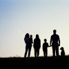 A family sillouhetted against the horizon.