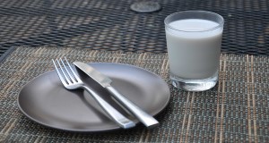 A metal plate with fork and knife, next to a glass of almond milk. Credit: Lincoln Zotarelli, UF/IFAS