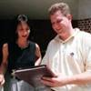 A man showing a book to a woman.