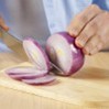 Someone slicing a red onion