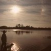 Man and dog enjoying the sunset by the water