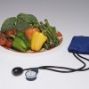 Plato de verduras y un manguito y monitor de presión arterial