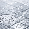 water splattered tile floor with a drain
