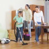 A mother, father, and son cleaning the house together.