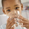 A little boy drinking a glass of water