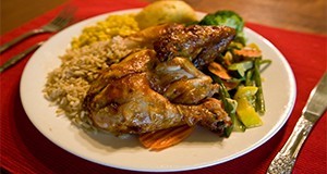 Una cena completa de pollo con arroz, maíz, pan y verduras al vapor.bread, and steamed vegetables.