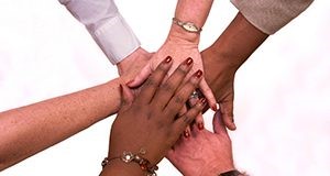 Hands put in a circle for a teamwork hand shake.