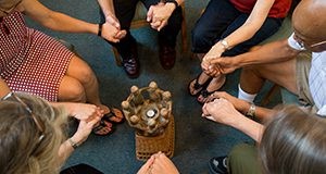 A support group of people sitting in a circle and holding hands