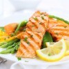Grilled salmon with lemon on fresh greens