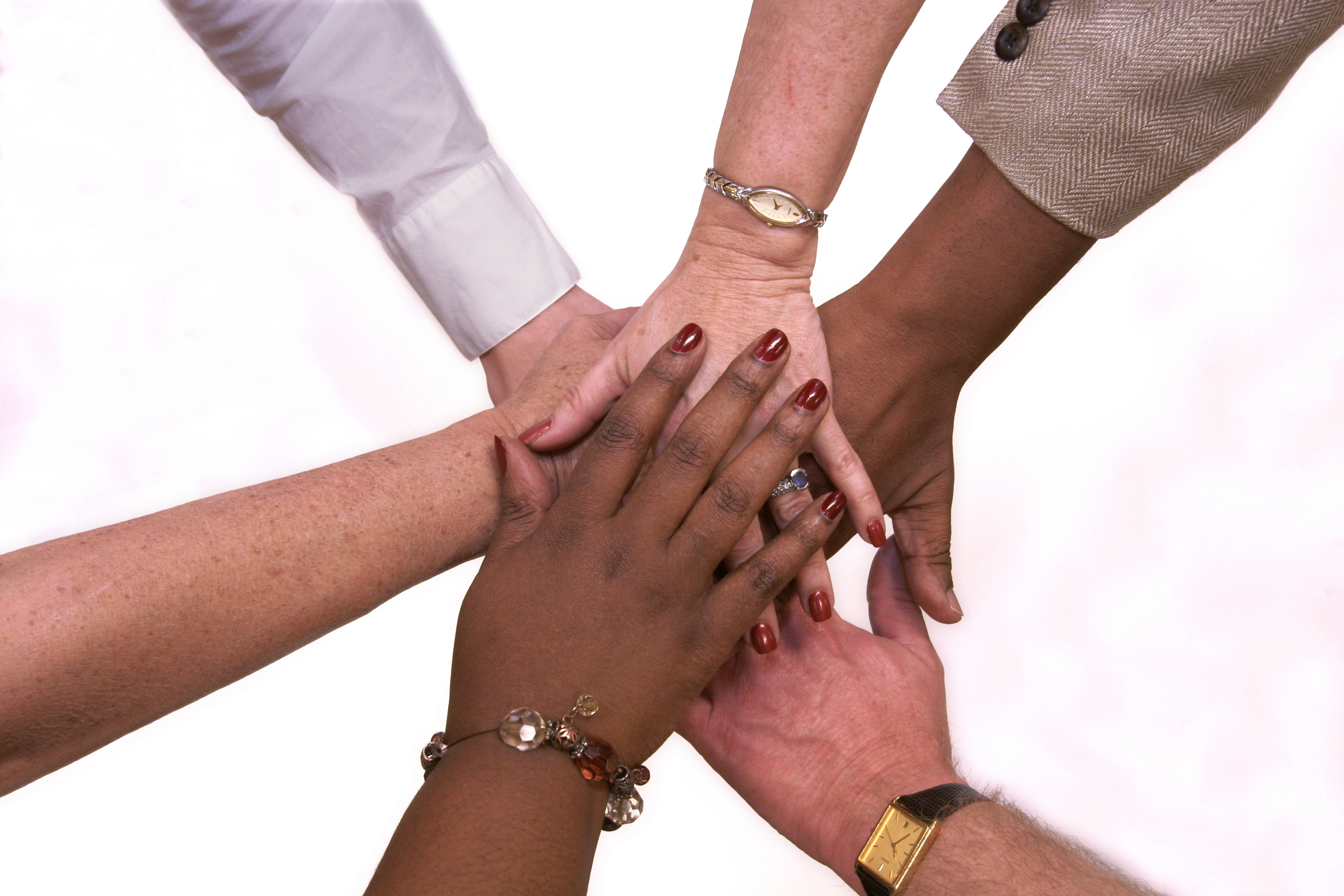 Members' hands at the center of a team circle for team handshake.