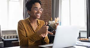 Woman signs "help" in ASL for an online video meeting.