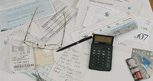 Assorted financial paperwork pertaining to debts and expenses on a table. UF/IFAS Photo by Thomas Wright. UF/IFAS File Photo.