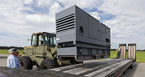 A diesel power generator being loaded onto a flatbed trailer. Photo taken 08-29-23. UF/IFAS Photo by Tyler Jones.