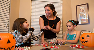 A parent and two children sort through Halloween candy. UF/IFAS Photo by Tyler Jones.